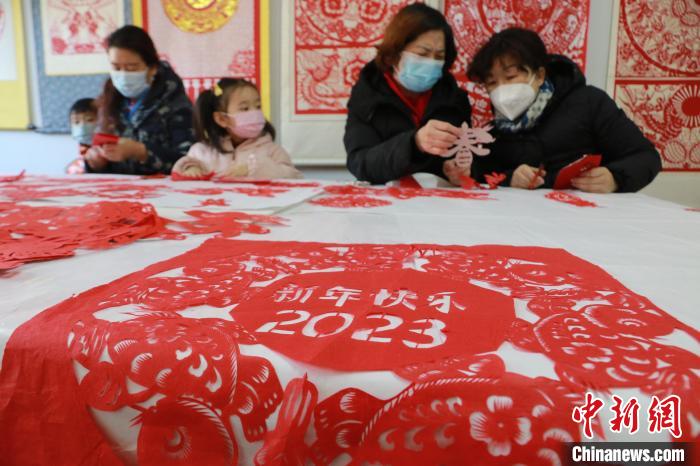 12月30日，在山東省高密市剪紙藝社，非遺傳承人和孩子們正在進(jìn)行迎新年剪紙創(chuàng)作?！±詈?攝