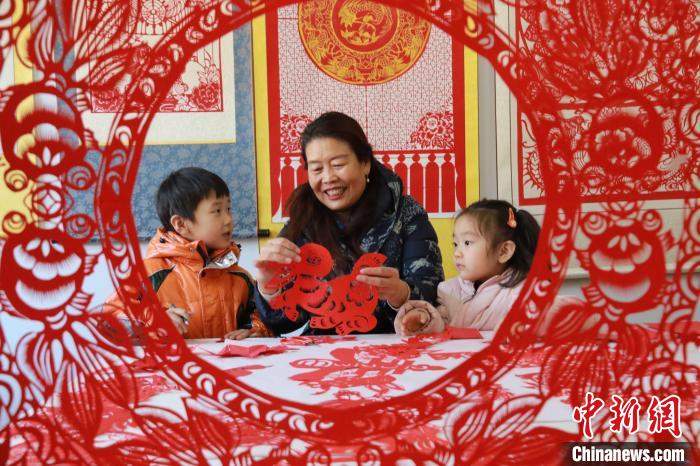 非遺傳承人田桂芹在帶領(lǐng)孩子們進(jìn)行迎新年剪紙創(chuàng)作?！±詈?攝