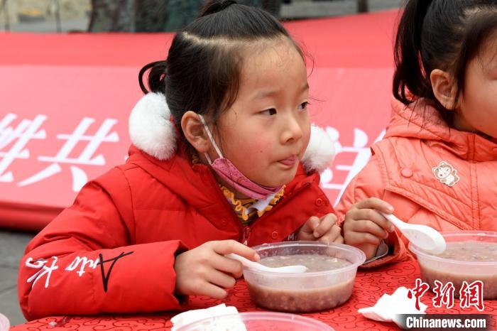 小朋友正在品嘗美味的臘八粥?！⊥醪?攝