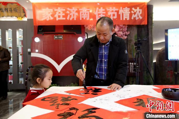 1月13日，山東濟南，書畫家現(xiàn)場潑墨，揮毫?xí)鴮懜Ｗ?、春?lián)?！O婷婷 攝