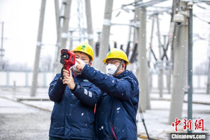 國網(wǎng)北京昌平供電公司運(yùn)維人員雪天在變電站對站內(nèi)設(shè)備開展巡視測溫?！⑿≤?攝