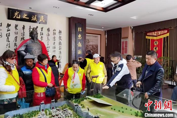 資料圖：岳然(右二)在向參觀人員講解岳飛故事?！『戏适性里w精神傳承研究會(huì)供圖