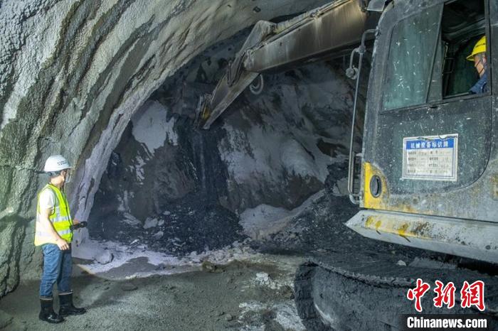 挖掘機(jī)小心翼翼開(kāi)展掌子面挖掘，站在旁邊的工人緊盯，時(shí)刻準(zhǔn)備叫停作業(yè)?！⒅铱?攝