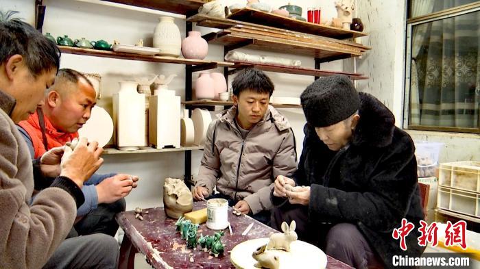 圖為張福高一家在捏制兔子?！『蚊髦?攝