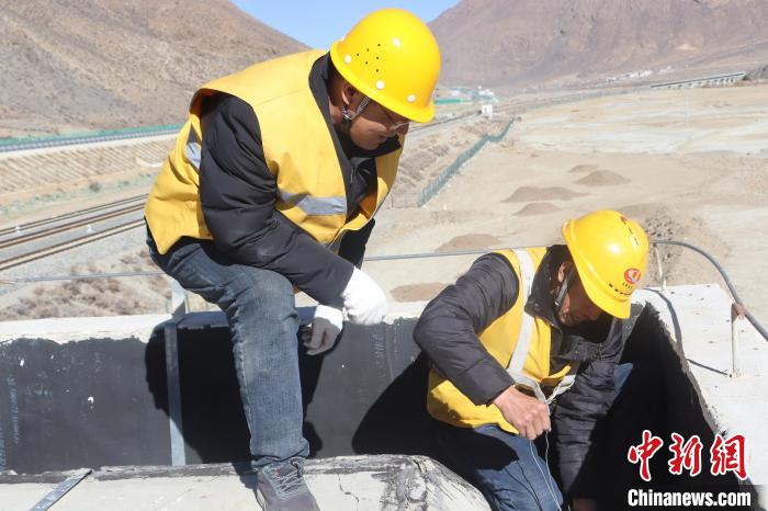 圖為馬智文(左)指導(dǎo)職工進(jìn)行站房屋頂排水孔的清理作業(yè)。　 馬生明 攝