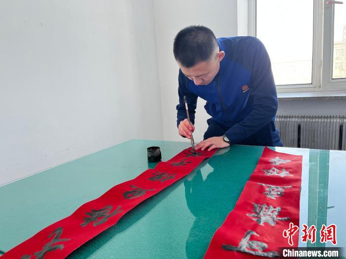 圖為森林消防指戰(zhàn)員自己動手寫春聯(lián)?！∶缱?攝