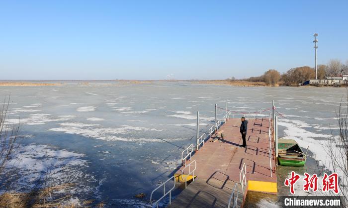 春節(jié)期間，李國忠在碼頭上觀察湖面。　陳康 攝
