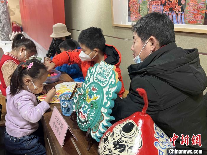 山東省級(jí)非遺侯氏社火臉譜傳承人侯志新在現(xiàn)場(chǎng)教小朋友畫(huà)臉譜?！∴嶊?攝