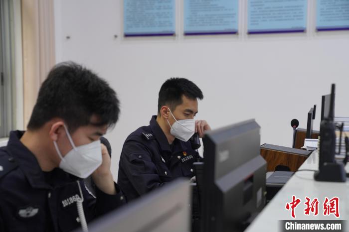 圖為民警黃昊與同事一同接聽報(bào)警電話?！⊥鯓s鑫 攝