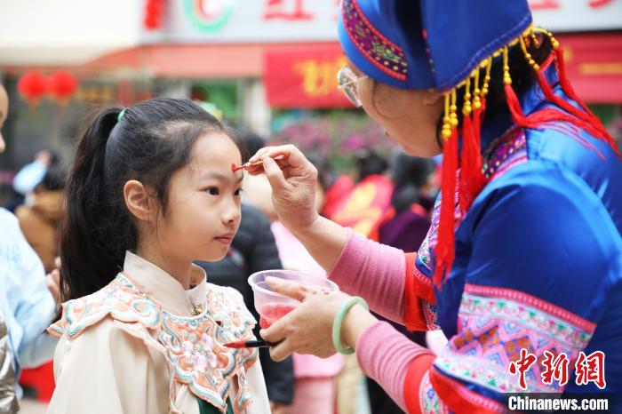 志愿者為小朋友點(diǎn)朱砂痣?！↑S曉君 攝