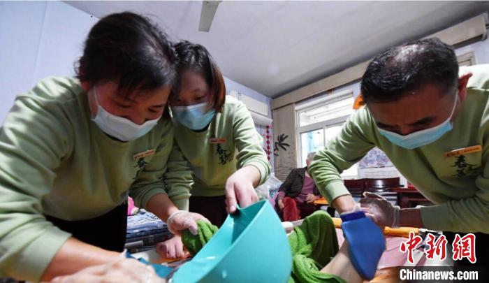 張慧和同事一起為老人進(jìn)行助浴服務(wù)。　受訪者供圖