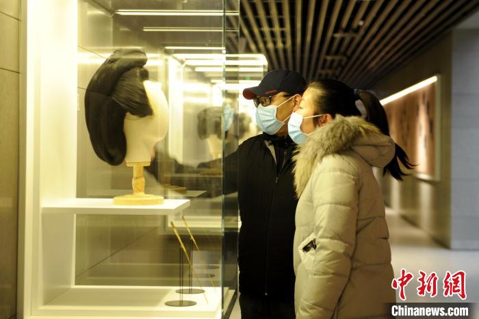 圖為市民觀(guān)賞古人發(fā)型展品?！「咪?攝