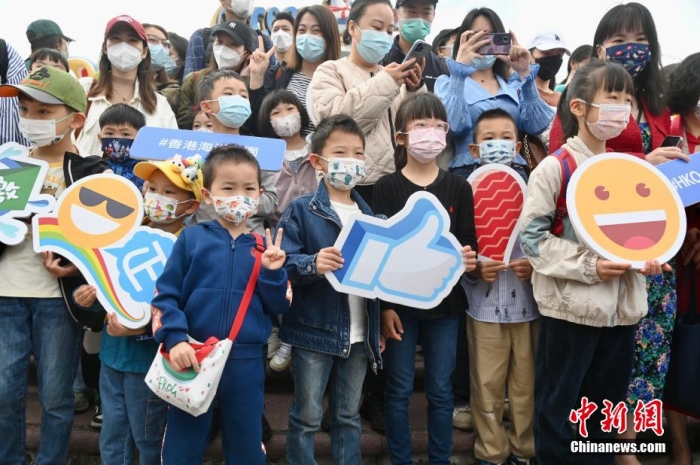 隨著香港與內(nèi)地全面“通關(guān)”，香港不少旅游活動(dòng)重啟。2月11日上午，香港海洋公園迎來(lái)全面復(fù)常后的首個(gè)內(nèi)地點(diǎn)對(duì)點(diǎn)旅行團(tuán)。該旅行團(tuán)約有140名內(nèi)地旅客由深圳蓮塘口岸乘坐跨境專車直達(dá)香港海洋公園，園方特地為旅行團(tuán)安排歡迎儀式，歡迎他們蒞臨香港海洋公園。圖為兒童手持表情圖案合影。李志華 攝