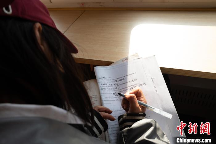 當(dāng)?shù)貙W(xué)生在“慢火車”上的學(xué)習(xí)車廂寫作業(yè)。　付瑜 攝