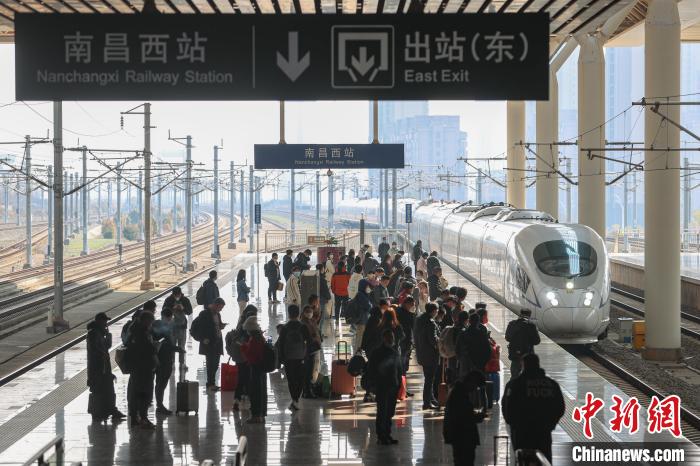 圖為江西南昌西站，一輛列車進站，旅客有序在站臺上候車?！⒘?攝