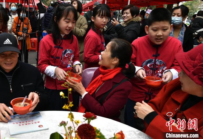 圖為福州市倉山區(qū)第五中心小學(xué)的學(xué)生為參加活動的社區(qū)老人送上拗九粥?！埍?攝