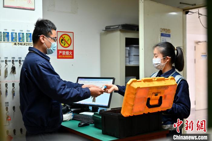 圖為咸俊領(lǐng)取工具。　俞靖 攝