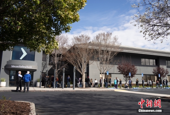 當(dāng)?shù)貢r(shí)間3月13日，客戶在美國加州圣克拉拉市硅谷銀行總部門前排隊(duì)等候辦理業(yè)務(wù)。美國聯(lián)邦儲(chǔ)備委員會(huì)和美國聯(lián)邦存款保險(xiǎn)公司(FDIC)12日發(fā)表聯(lián)合聲明，宣布采取行動(dòng)確保硅谷銀行等存款機(jī)構(gòu)儲(chǔ)戶的資金安全。聲明稱，在收到美聯(lián)儲(chǔ)和聯(lián)邦存款保險(xiǎn)公司的建議并與美國總統(tǒng)進(jìn)行協(xié)商后，財(cái)政部長耶倫批準(zhǔn)采取行動(dòng)，使聯(lián)邦存款保險(xiǎn)公司能夠以充分保護(hù)所有存款人的方式解決硅谷銀行問題。從3月13日起，硅谷銀行儲(chǔ)戶將可以使用所有資金。與硅谷銀行解決問題有關(guān)的任何損失都不由納稅人承擔(dān)。<a target='_blank' href='/'>中新社</a>記者 劉關(guān)關(guān) 攝