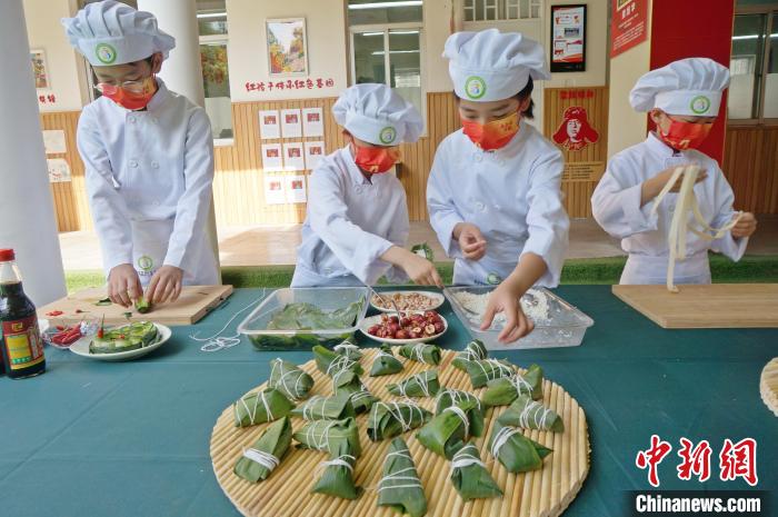 圖為鄭州小學(xué)生體驗(yàn)包粽子。(資料圖) 韓章云 攝