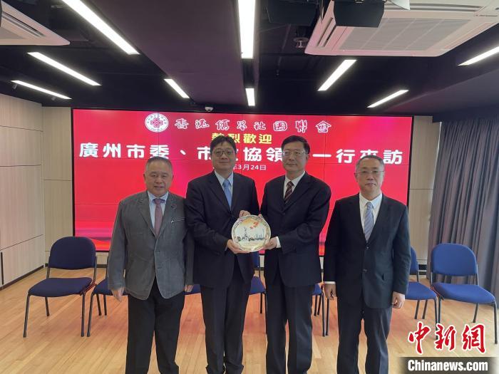 中共廣州市委常委、統(tǒng)戰(zhàn)部部長王世彤(右二)向香港僑界社團(tuán)聯(lián)會(huì)會(huì)長黃楚基(左二)致送紀(jì)念品?！∠愀蹆S界社團(tuán)聯(lián)會(huì)供圖