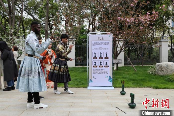 圖為外國(guó)青年身著漢服玩投壺游戲?！∧喜咚芍腥沼押脮?huì)館 供圖