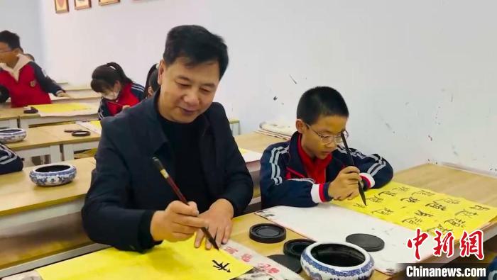 圖為“校長爺爺”同學(xué)生們一起練書法。　陳峰 攝