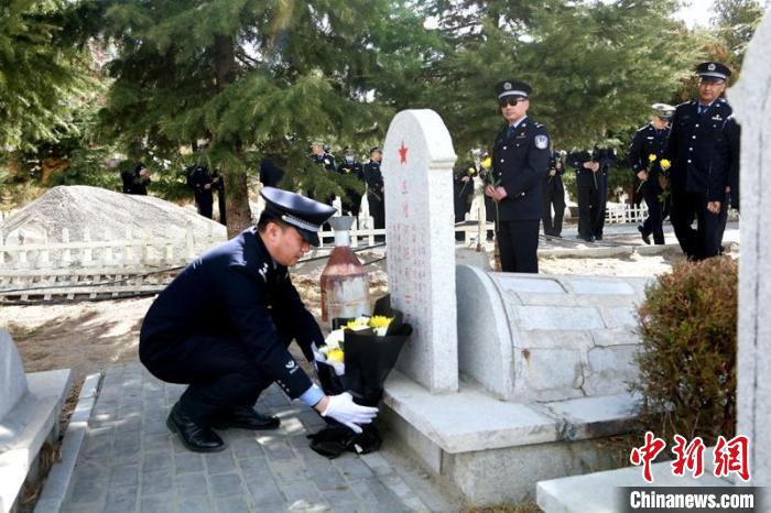 圖為西藏邊檢總站執(zhí)法調(diào)查支隊(duì)民警為旦增阿旺烈士擦拭墓碑、敬獻(xiàn)鮮花?！⒚麝?yáng) 攝