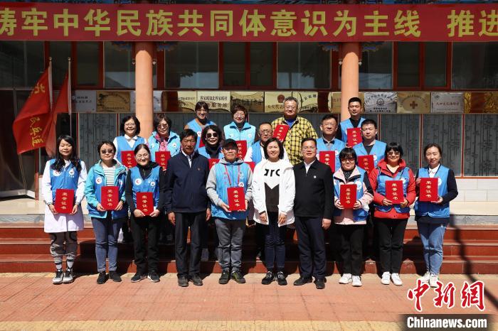 北穆家峪村第一書記陳錦榮(前排右四)代表村“兩委”向北京市和平里醫(yī)院專家團隊頒發(fā)榮譽證書?！±钛┓?攝