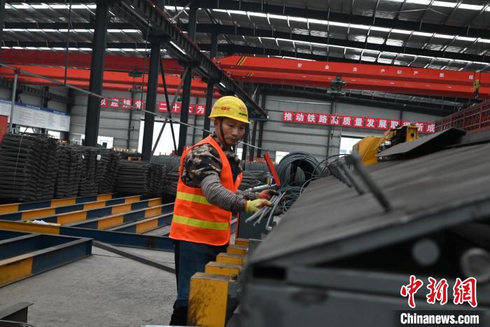 圖為工人正在操作鋼筋加工設(shè)備?！埿?攝