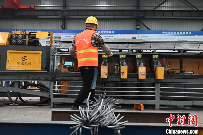 圖為工人在操作鋼筋加工智能設(shè)備?！埿?攝