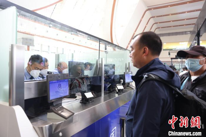 圖為民警驗(yàn)放旅客。　磨憨邊檢站供圖