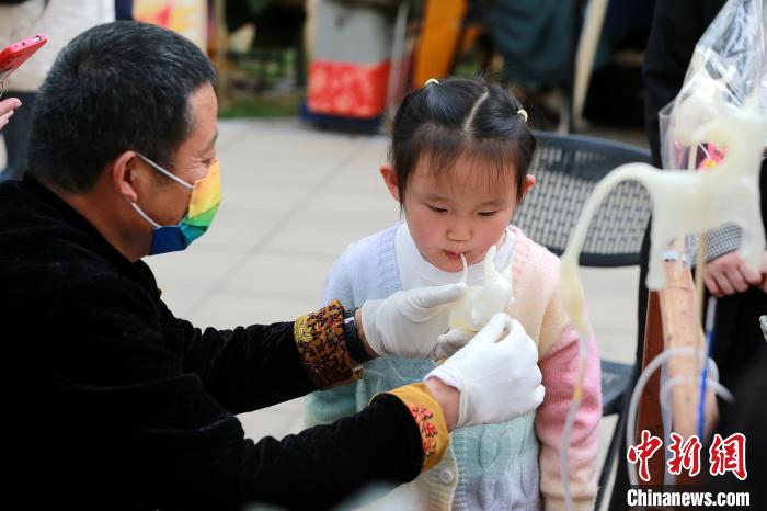 小朋友在春季黃河大集上體驗(yàn)吹糖人?！×籂?攝