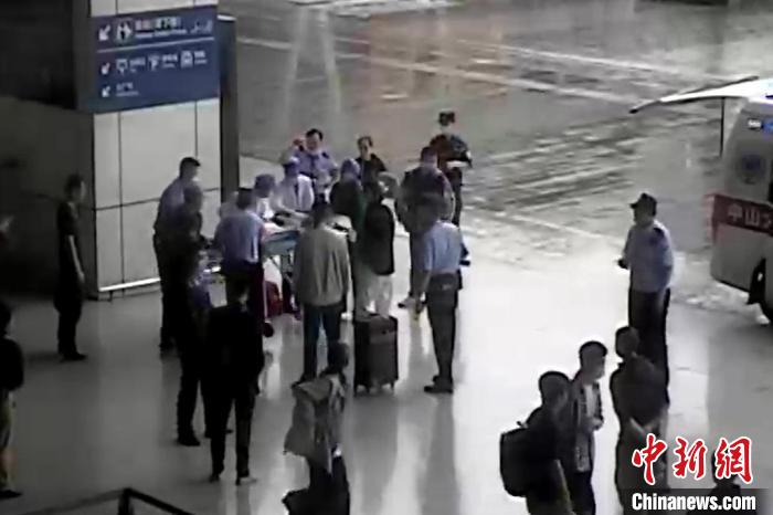 眾人合力將老人送上救護(hù)車。　監(jiān)控畫面 攝