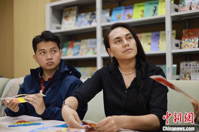 留學(xué)生們正在動(dòng)手制作中國傳統(tǒng)玩具?！⌒吕俪霭嫔绻﹫D