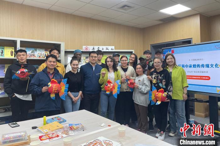 留學(xué)生們手持親手制作的中國傳統(tǒng)玩具合影留念。　新蕾出版社供圖