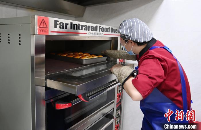 女性戒毒人員正在制作面包?！埇?攝