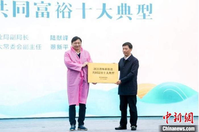 浙江省林業(yè)局副局長陸獻(xiàn)峰(左)為浙江省林業(yè)推進(jìn)共同富裕十大典型授牌現(xiàn)場?！”P峰鄉(xiāng)人民政府 供圖