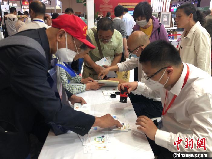 圖為集郵愛(ài)好者在現(xiàn)場(chǎng)加蓋郵戳。　葉娜 攝