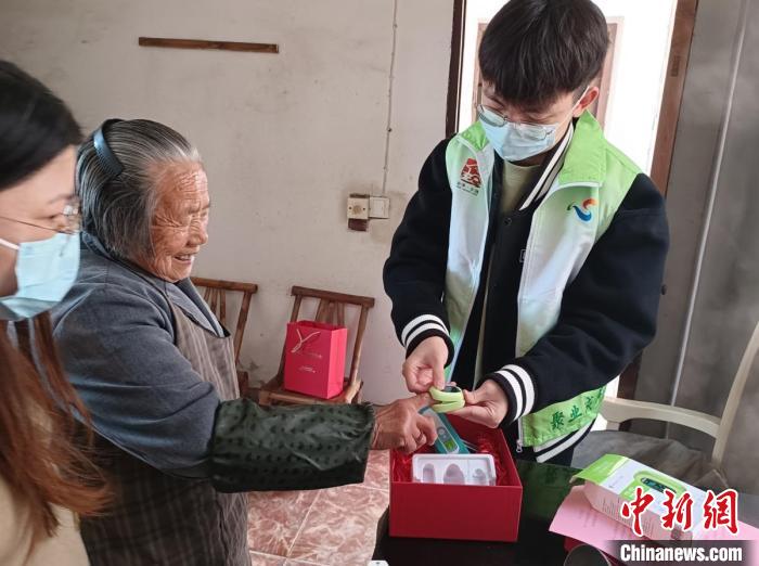 指導(dǎo)僑界老人使用血氧儀?！＄娦?攝