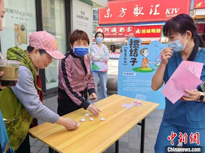 阿姨們熟練地玩起“摜結(jié)子”?！≠Z宇巍 攝