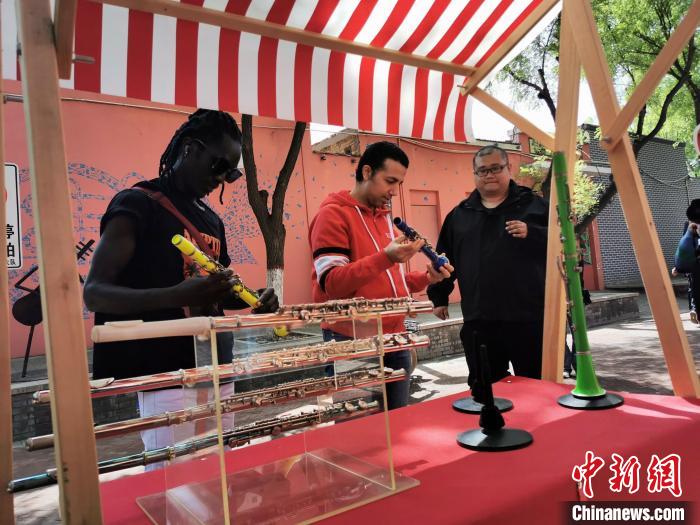 外籍友人在“樂器大集”上挑選樂器?！⊥貔i 攝