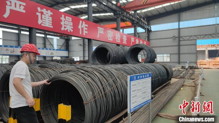 錢(qián)盛鵬正在物資堆放區(qū)檢查鋼筋質(zhì)量?！∴嚦?攝