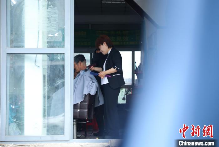 周麗麗正在給客人理發(fā)?！￡惣覙?攝