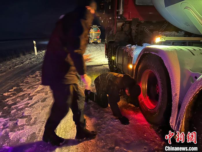 圖為民警幫助受困車輛安裝防滑鏈?！」逯菸麄鞑抗﹫D