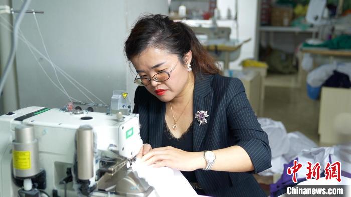 圖為李王花上機操作縫紉服裝?！￡愑⑶?攝