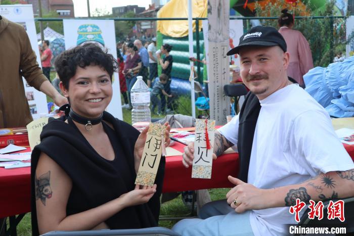 當(dāng)?shù)孛癖娫跐h字體驗(yàn)工作坊展示自己手寫(xiě)的中文名書(shū)簽?！◆斻肟鬃訉W(xué)院供圖