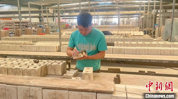 脫模取坯時(shí)要控制好坯體的干濕度，輕拿輕放，防止坯體變形。　楊靜 攝