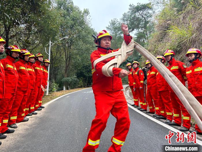 鐘曉金正在向隊員們展示如何快速回收消防水帶?！《拍弦?攝