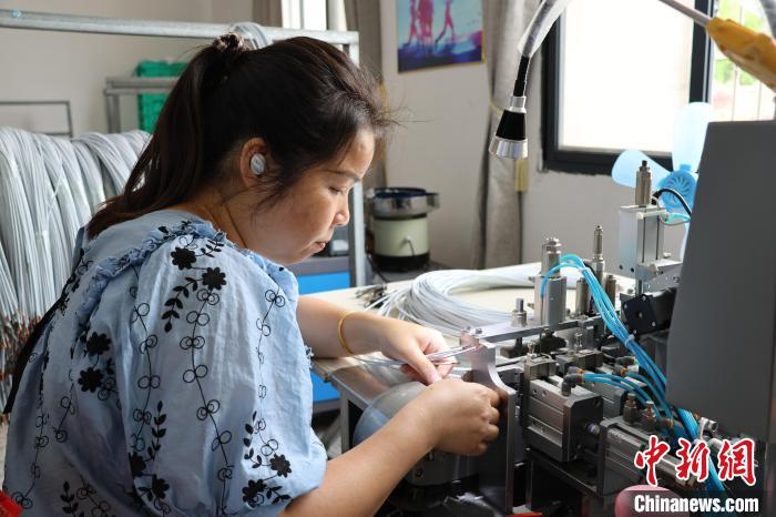 車頭村本地工人正在給數(shù)據(jù)線焊錫?！⒀┤?攝