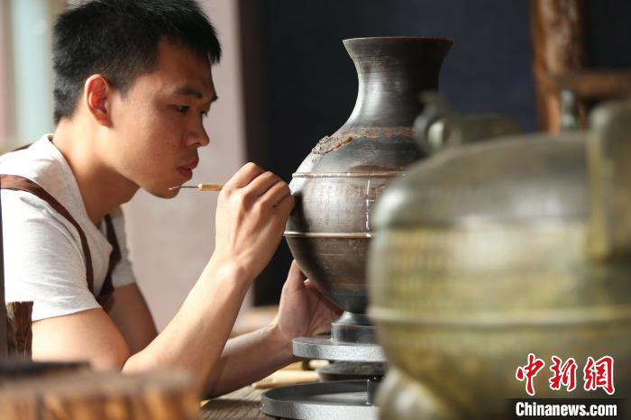 黃子爵正在為中山國文創(chuàng)產(chǎn)品刻銘文。(資料圖) 黃子爵供圖